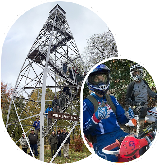 A person on a motorcycle and some people climbing up the tower