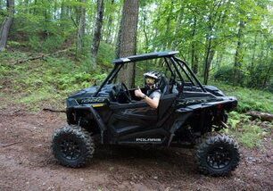 A man riding in the back of an atv.